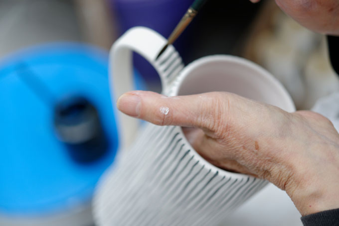 Sue Binns decorating in her studio in London 2013 - Cobalt is applied over a matt glaze.